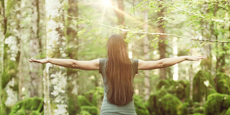 Frau fühlt die positive Energie beim Waldbaden